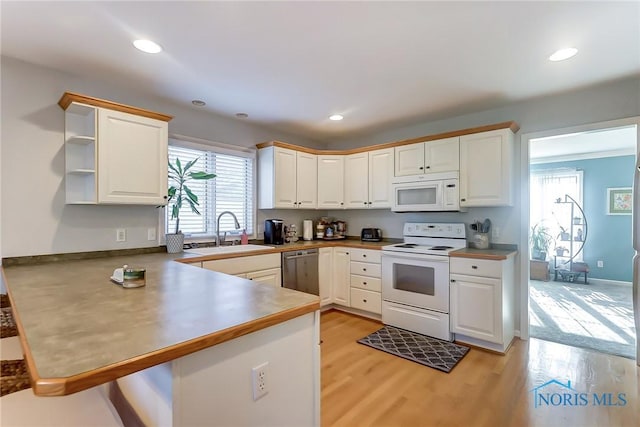 kitchen with white cabinets, white appliances, and kitchen peninsula