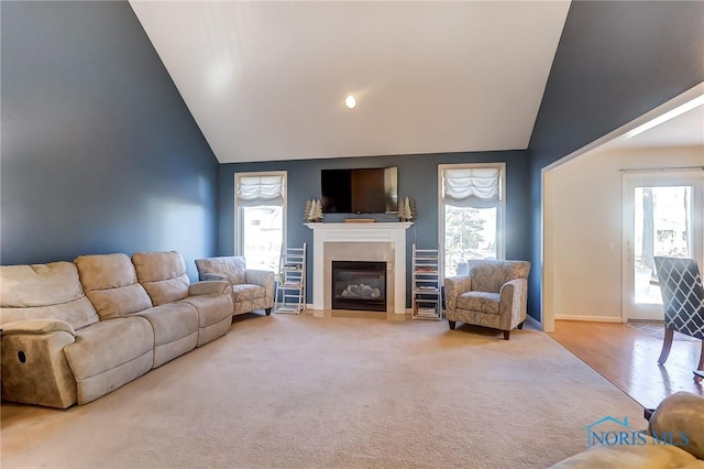 living room with plenty of natural light, lofted ceiling, and carpet