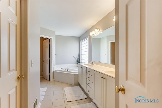 bathroom featuring tile patterned floors, vanity, and a tub