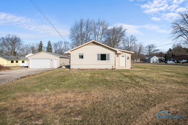 view of front facade with an outbuilding, a garage, and a front yard