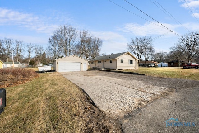 view of front facade featuring an outbuilding, a garage, and a front yard