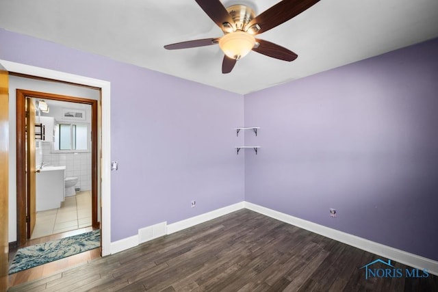 empty room featuring ceiling fan and hardwood / wood-style floors