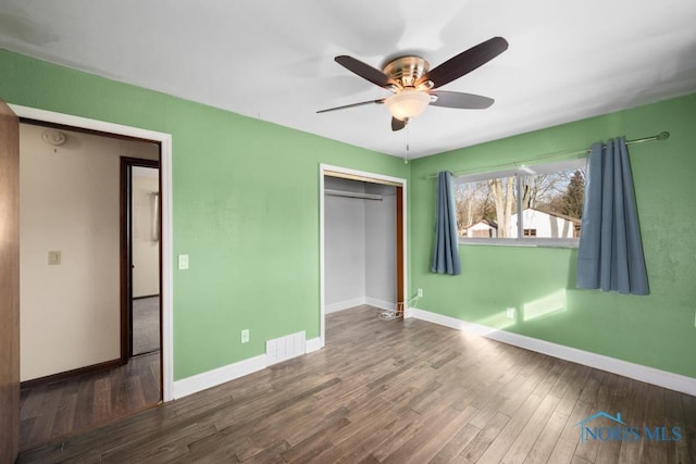 unfurnished bedroom featuring hardwood / wood-style floors, a closet, and ceiling fan