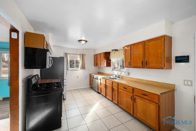 kitchen with stainless steel appliances, sink, and light tile patterned floors