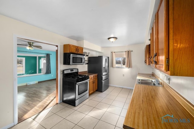 kitchen featuring ceiling fan, appliances with stainless steel finishes, sink, and light tile patterned floors