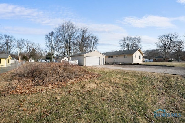 exterior space with a garage, an outdoor structure, and a front lawn