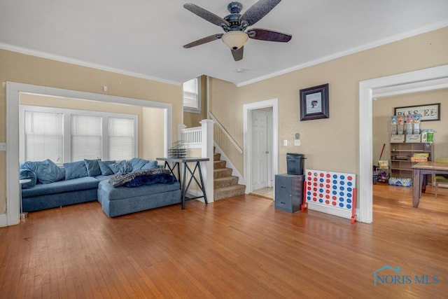 living room with hardwood / wood-style flooring, crown molding, and ceiling fan