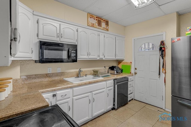 kitchen featuring sink, a paneled ceiling, black appliances, and white cabinets