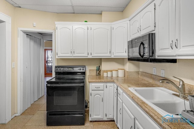 kitchen with white cabinetry, a drop ceiling, sink, and black appliances