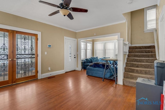 entryway with wood-type flooring, ornamental molding, french doors, and ceiling fan