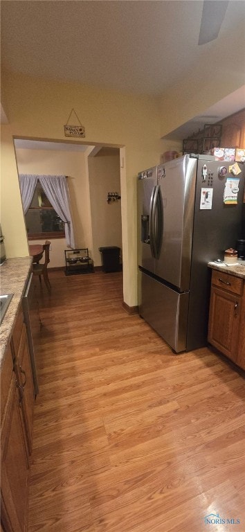 kitchen featuring stainless steel fridge and light hardwood / wood-style floors