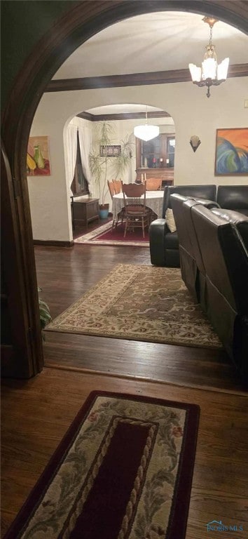 interior space featuring ornamental molding, dark hardwood / wood-style floors, and a chandelier