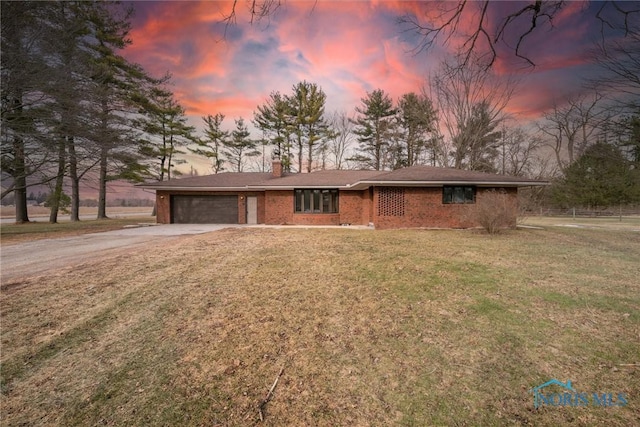 ranch-style house with a garage and a lawn