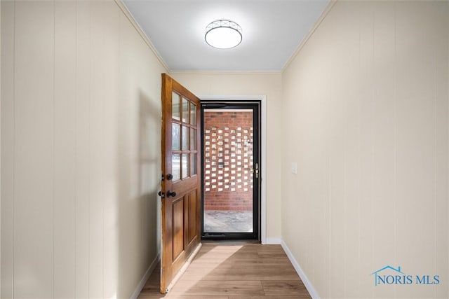 doorway to outside featuring ornamental molding and light wood-type flooring