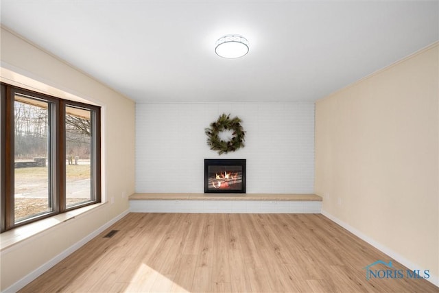 unfurnished living room featuring a wealth of natural light and light wood-type flooring