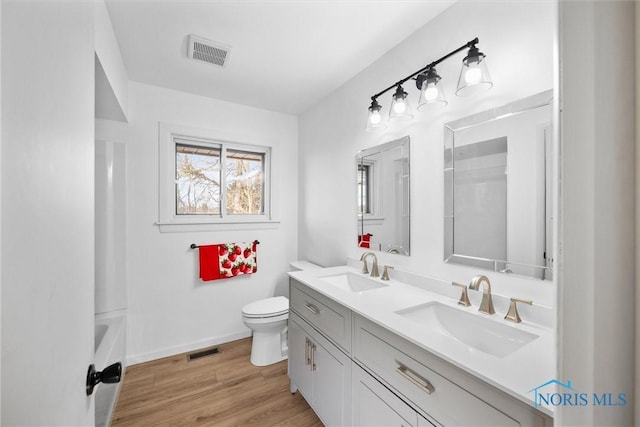 bathroom featuring vanity, hardwood / wood-style floors, and toilet