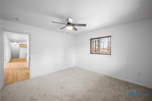 empty room featuring ceiling fan and light colored carpet