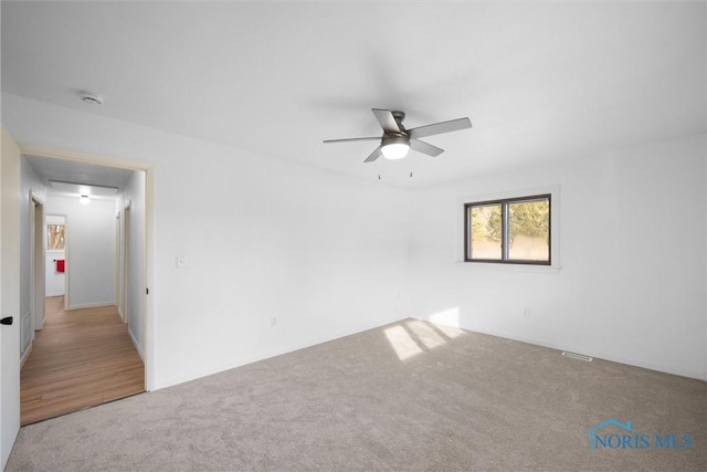 carpeted empty room featuring ceiling fan