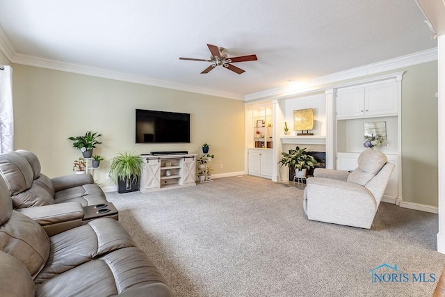 carpeted living room with crown molding, built in shelves, and ceiling fan