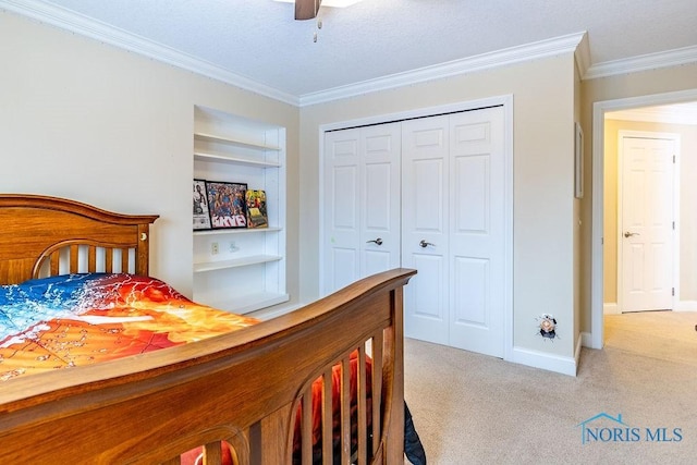 carpeted bedroom featuring ceiling fan, ornamental molding, and a closet