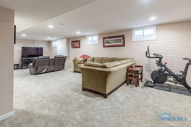 carpeted living room with brick wall