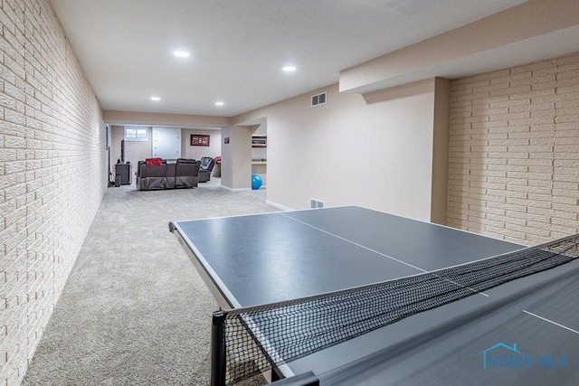 playroom featuring brick wall and light carpet