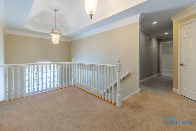 hallway featuring light carpet, a tray ceiling, and crown molding