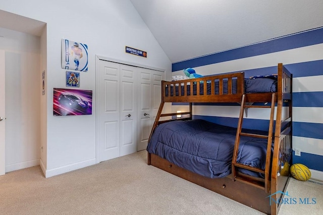 bedroom with lofted ceiling, carpet floors, and a closet