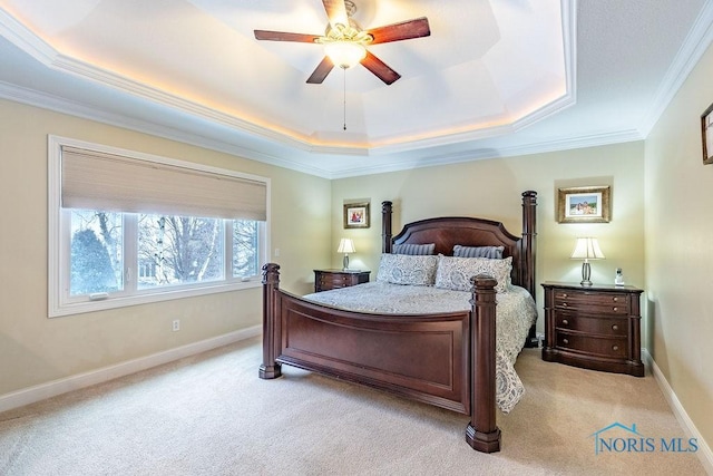 bedroom with ceiling fan, ornamental molding, a tray ceiling, and light colored carpet