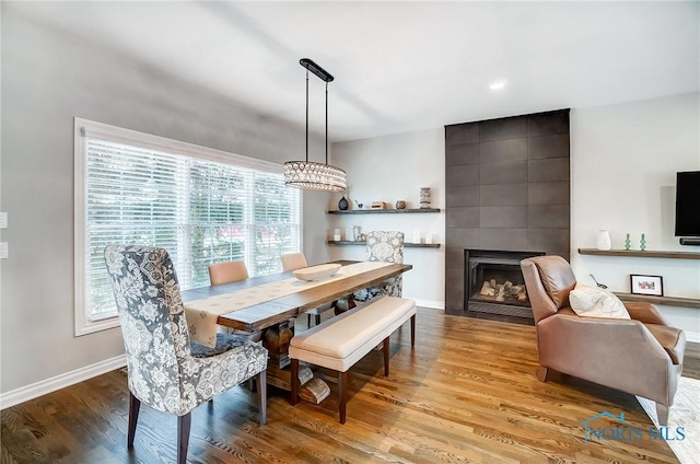 dining area with plenty of natural light, a tile fireplace, and light hardwood / wood-style flooring