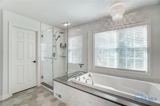 bathroom featuring plus walk in shower and a chandelier