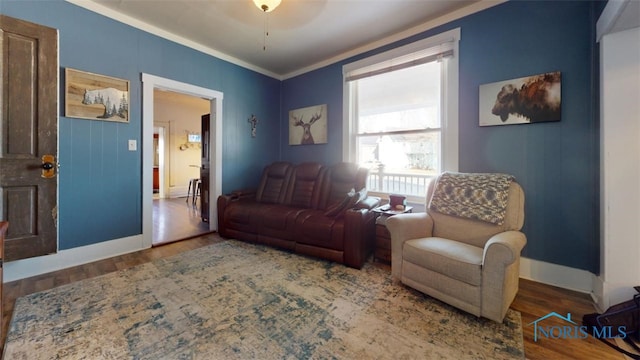 living area with wood-type flooring and ornamental molding