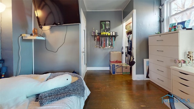 bedroom with crown molding and dark hardwood / wood-style floors