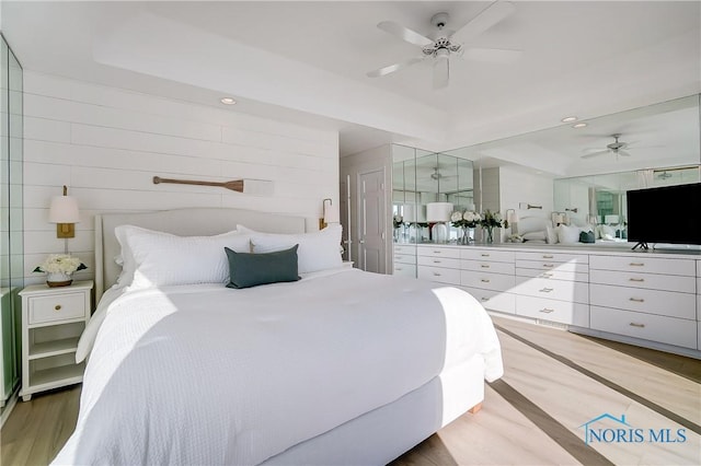 bedroom featuring ceiling fan and a raised ceiling