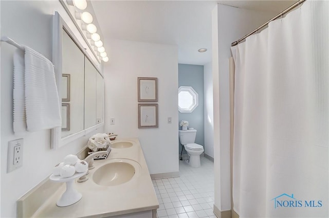 bathroom featuring tile patterned flooring, vanity, and toilet