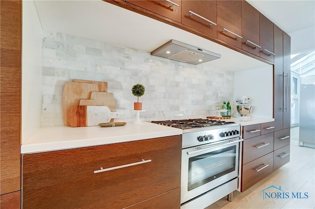 kitchen with ventilation hood, tasteful backsplash, and stainless steel stove