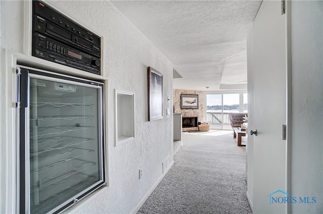 hall with carpet flooring and a textured ceiling