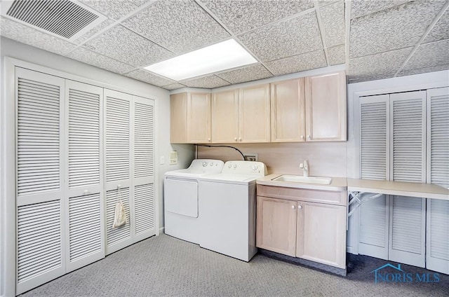 laundry area with cabinets, washing machine and dryer, sink, and light carpet