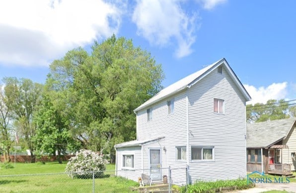 back of house with a lawn