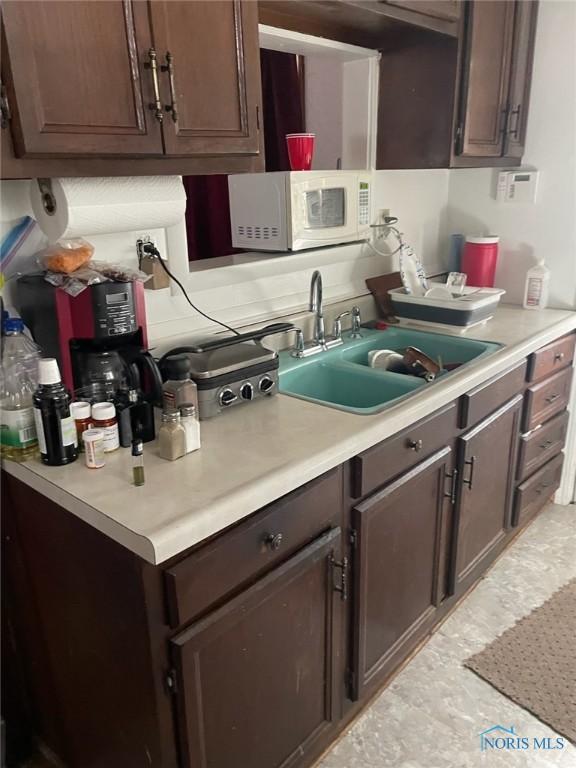 kitchen with sink and dark brown cabinetry