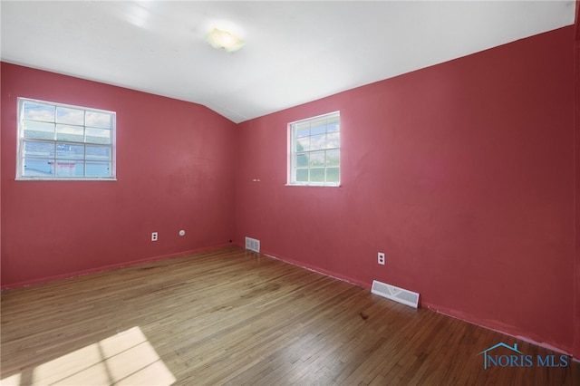 unfurnished room with vaulted ceiling and hardwood / wood-style floors