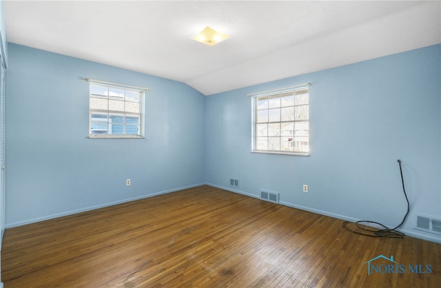 unfurnished room featuring vaulted ceiling and hardwood / wood-style floors