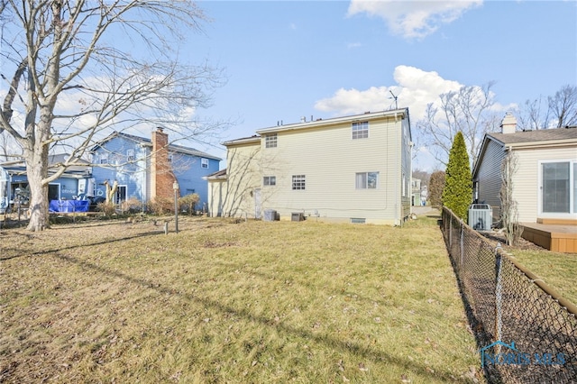 back of property with cooling unit and a lawn