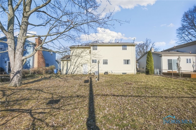 rear view of house with a yard and central AC