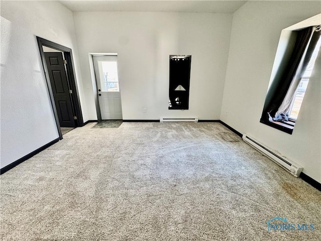 unfurnished room featuring light colored carpet and baseboard heating