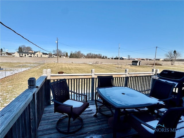 deck with a grill, a rural view, and a lawn