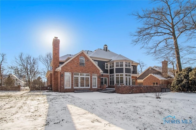 view of snow covered rear of property