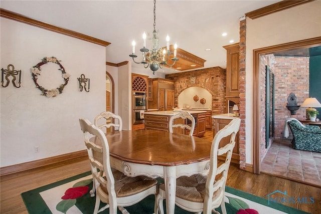 dining space featuring an inviting chandelier, ornamental molding, and dark hardwood / wood-style floors