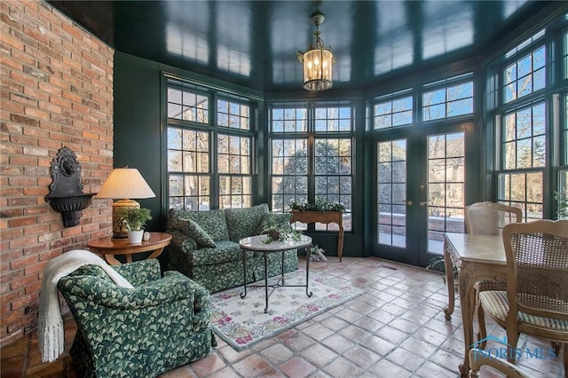 sunroom / solarium featuring plenty of natural light and a chandelier