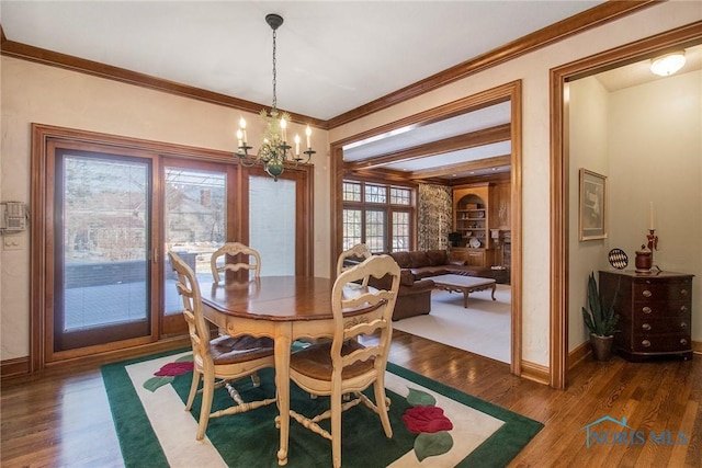 dining room featuring an inviting chandelier, ornamental molding, dark hardwood / wood-style floors, and built in features